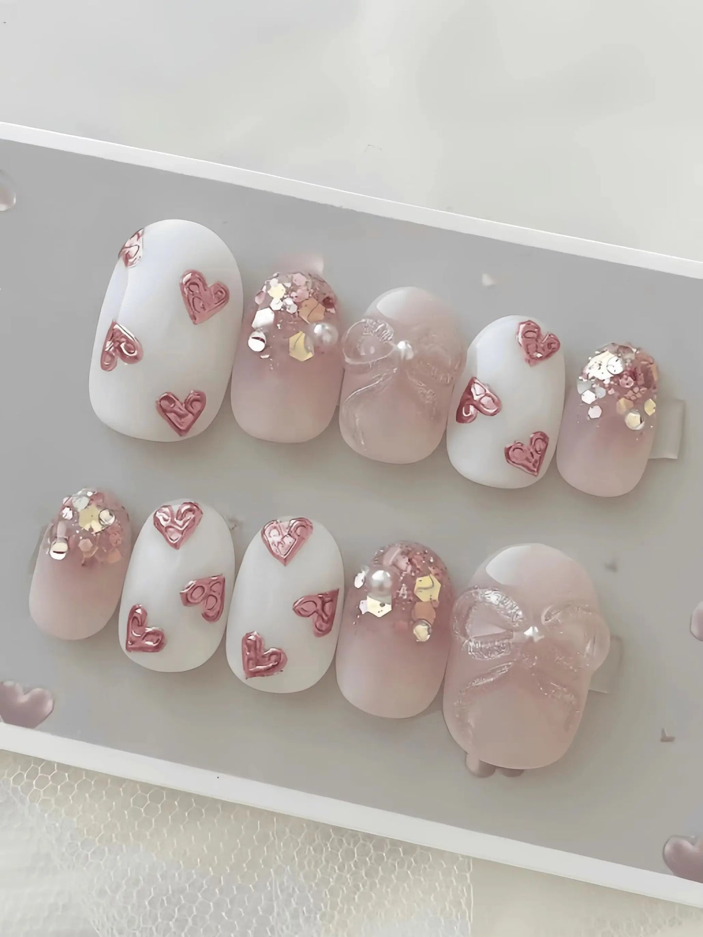 10 Pieces of Handmade Almond-Shaped Full-Cover Nail Tips, Medium Length, with Nude Pink Gradient and Translucent Base, Featuring Embossed Pink Hearts, Glitter Sequins, and Fine Glitter Bow Pearl Decorations, in a Gentle and S